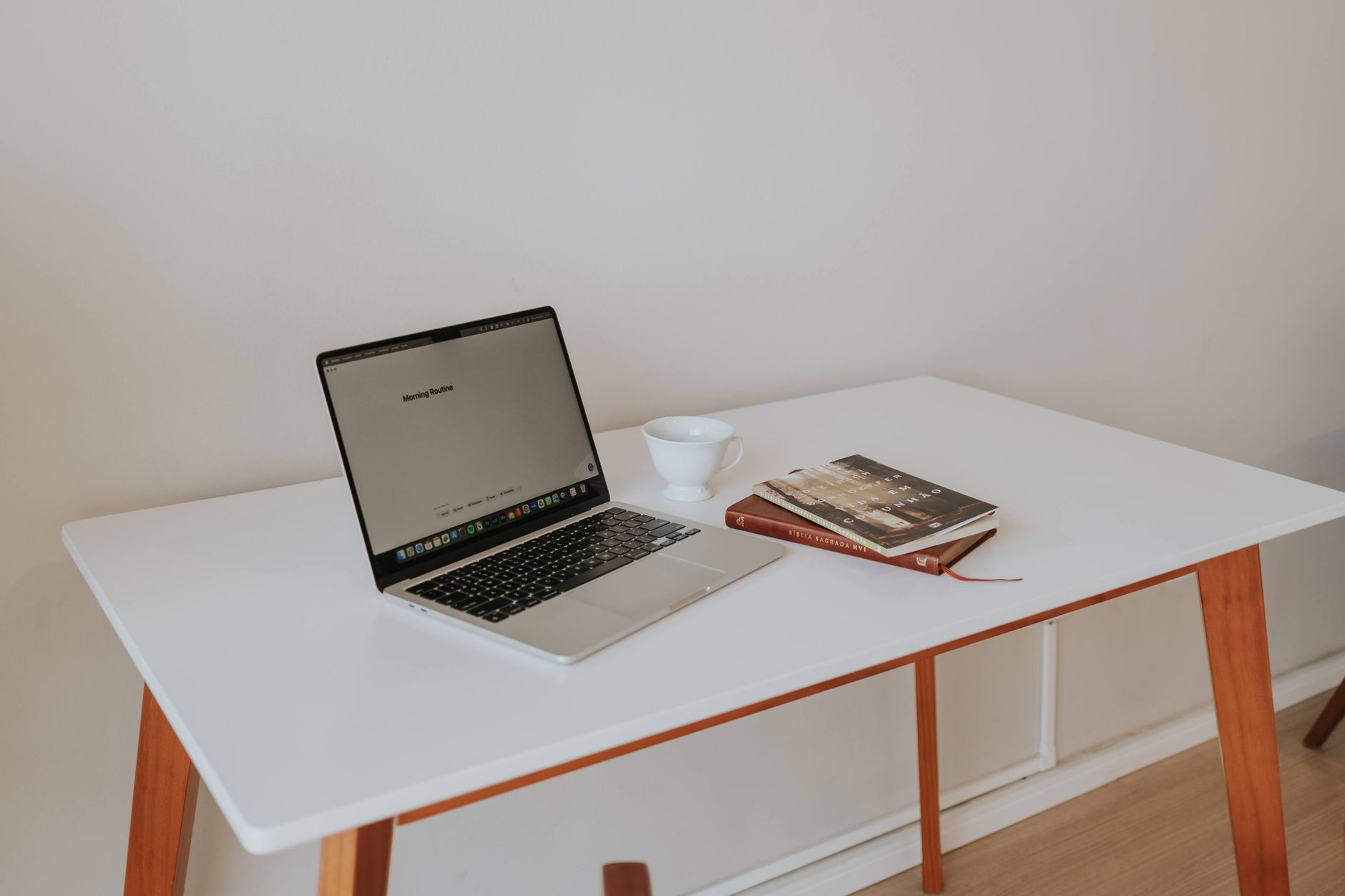 Aufgeräumter Schreibtisch mit Laptop, Büchern und Kaffee