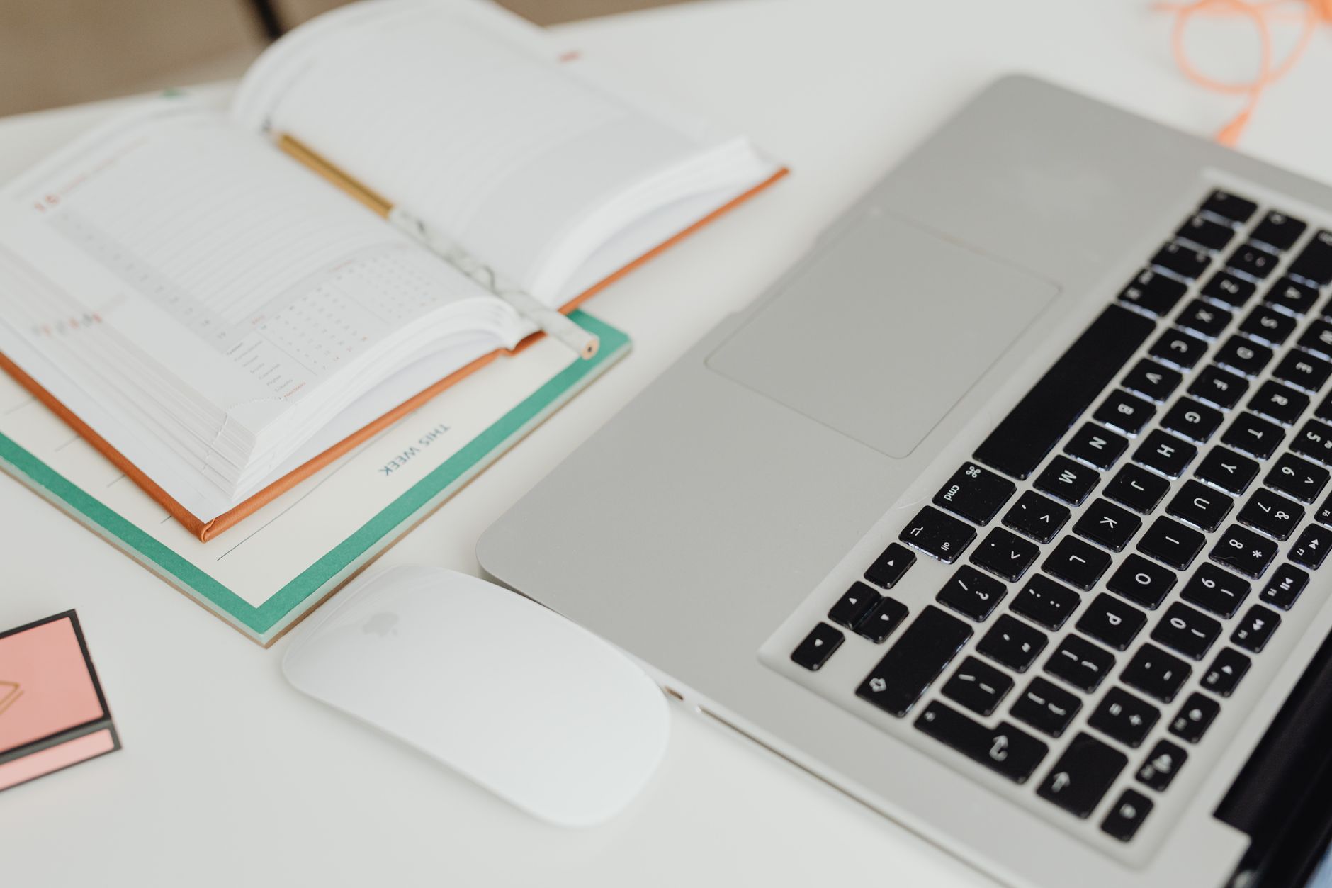 Arbeitsplatz mit Laptop und geöffnetem Planer